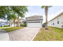 Charming two-story home with an attached two-car garage and a beautiful paved driveway at 1204 Blackheath Ct, Davenport, FL 33897
