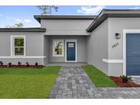 Charming home featuring a blue front door and a well-maintained brick walkway at 15823 Sw 27Th Avenue Rd, Ocala, FL 34473