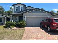Charming two-story home with a brick driveway and well-maintained landscaping at 17333 Cagan Crossings Blvd, Clermont, FL 34714