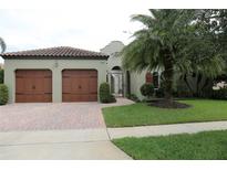 Charming home featuring a two-car garage, well-kept lawn, and tile roofing at 7415 Pointe Venezia Dr, Orlando, FL 32836