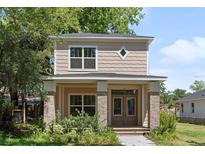 Charming two-story home with a covered front porch, brick accents and manicured landscaping at 805 S Locust Ave, Sanford, FL 32771