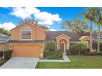 Inviting two-story home with well-maintained landscaping, mature palms, and attached two-car garage at 847 Coventry Rd, Davenport, FL 33897