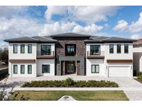 Beautiful modern two-story home with stone accents, a tile roof, and manicured landscaping at 1014 Jack Nicklaus Ct, Reunion, FL 34747
