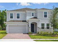Charming two-story home with gray siding, stone accents, and manicured front yard at 1169 Happy Forest Loop, Deland, FL 32720