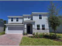 Charming two-story home featuring a two-car garage, stone accents, and well-manicured lawn at 1169 Happy Forest Loop, Deland, FL 32720
