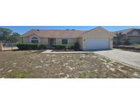Charming one-story home featuring a well-manicured front yard and an attached two-car garage at 129 Valentino Ct, Davenport, FL 33837
