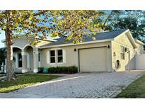 Beige home featuring an attached garage and beautiful brick paver driveway at 145 Burns Ave, Longwood, FL 32750