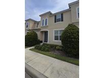 Charming two-story home with landscaped yard and inviting front entrance with glass paneled door at 1569 Carey Palm Cir, Kissimmee, FL 34747