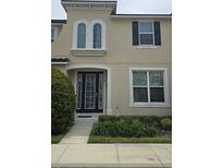 Charming two-story home with a black-framed front door, arched window and well-maintained landscaping at 1569 Carey Palm Cir, Kissimmee, FL 34747