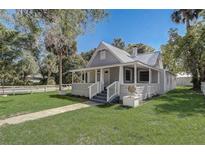 Charming home featuring a quaint porch, well-maintained lawn, and a classic gray exterior finish at 246 N Oak Ave, Orange City, FL 32763