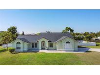 Charming single-story home featuring a well-manicured lawn, arched windows, and a neutral color palette at 2984 Monica Ter, Kissimmee, FL 34744