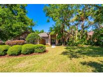 Inviting home showcasing lush landscaping with manicured bushes, mature trees, and a well-maintained lawn at 3831 River Hollow Ct, Oviedo, FL 32765
