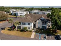 Exterior view of a two-story condo building with reserved parking and tropical landscaping at 3960 Southpointe Dr # 501, Orlando, FL 32822