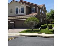 Two-story home featuring a tile roof, a brick-paved driveway, and a two-car garage at 5341 Via Appia Way, Sanford, FL 32771