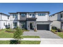 Stunning two-story home boasting modern design, stone accents, a well-manicured lawn and a gray paved driveway at 6301 Sand Skipper Rd, Orlando, FL 32821