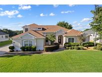 Charming home featuring lush landscaping, a well-manicured lawn, and a welcoming front entrance at 7351 Spring Mountain Ln, Yalaha, FL 34797