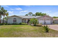 Charming single-story home with a manicured front lawn and a two-car garage in a residential neighborhood at 8444 Sandberry Blvd, Orlando, FL 32819