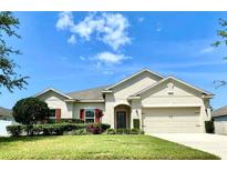 Charming single-story home featuring a well-manicured lawn, neutral color palette, and a two-car garage at 865 Bay Bridge Cir, Apopka, FL 32703