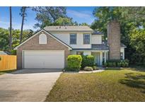 Charming two-story home featuring a brick chimney, attached two-car garage, and well-maintained landscaping at 992 Woodrose Ct, Altamonte Springs, FL 32714