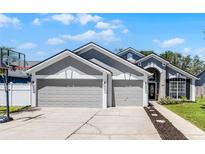 Charming home featuring a three-car garage, neutral color palette and a basketball hoop at 1008 W Riviera Blvd, Oviedo, FL 32765