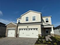 Inviting two-story home with stone accents, a three-car garage, and a well-manicured walkway at 1157 Basalt Ln, Sanford, FL 32771