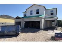 Image shows a two-story home under construction with a large garage and materials in the yard at 1157 Basalt Ln, Sanford, FL 32771