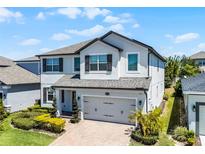 Charming two-story home with a two-car garage, landscaped yard, and neutral exterior at 13320 Magnolia Valley Dr, Clermont, FL 34711