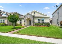 Charming single-story home with stone accents, a well-manicured lawn, and tidy landscaping at 1540 Softshell St, St Cloud, FL 34771