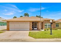 Charming single-story brick home with a well-manicured lawn and a convenient two-car garage at 633 Watercrest Dr, Haines City, FL 33844