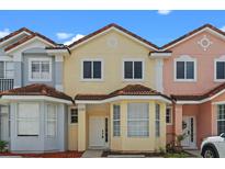 Charming townhomes with colorful facades, brown tile roofs, and well-maintained landscaping at 1236 S Beach Cir, Kissimmee, FL 34746
