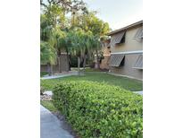 Exterior view showcasing the lawn, landscaping, and architectural details of the building at 130 Jasmine Woods Ct # 6D, Deltona, FL 32725
