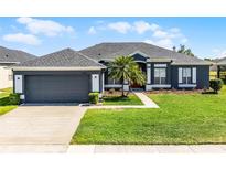 Charming single-story home boasts a well-manicured lawn and attached two-car garage at 13606 Summer Rain Dr, Orlando, FL 32828