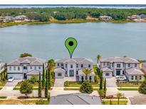 Luxury waterfront home with modern design, lush landscaping, and serene lake views at 16808 Bolsena Dr, Bella Collina, FL 34756
