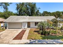 Charming single-story home with attached garage, manicured lawn, and lovely front porch at 2623 Parsley Dr, Orlando, FL 32837