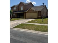 Two-story home showcasing a spacious driveway, attached garage, and manicured lawn at 301 Blue Bayou Dr, Kissimmee, FL 34743
