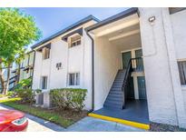 Two-story exterior view of condo building with stairs leading to upper units at 4117 S Semoran Blvd # 17, Orlando, FL 32822