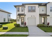 Charming townhouse with a well-maintained lawn, a private garage and walkway leading to the front door at 646 Longboat Dr, Davenport, FL 33896
