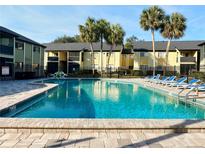 Community pool with blue lounge chairs and palm trees surrounding building at 912 Lake Destiny Rd # D, Altamonte Springs, FL 32714