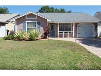 Charming single-story home with a well-manicured lawn, tiled walkway and attached one car garage at 9313 Pavillion Dr, Orlando, FL 32825