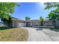 Charming single-story home featuring a two-car garage, a welcoming front yard, and solar panels on the roof at 941 Barbados Ave, Orlando, FL 32825