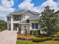 Beautiful two-story home with manicured landscaping, covered balcony, and paver driveway on a sunny day at 9421 Dugard Ct, Orlando, FL 32827