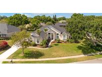 Charming home with lush landscaping, a well-manicured lawn, and a welcoming entrance at 11401 Willow Stowe Ln, Windermere, FL 34786