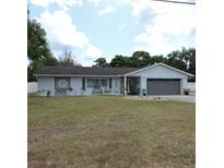 Charming one-story home featuring a well-manicured lawn, tidy landscaping, and a two-car garage at 1160 Rolling Acres Dr, Deland, FL 32720