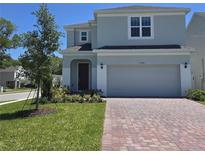 Charming two-story home with a well-manicured lawn and brick driveway at 1243 Bear Oak Ln, Deland, FL 32720