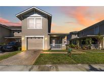 Charming two-story townhome with a well-manicured lawn, a brick driveway, and an attached garage at 2016 Cypress Bay Blvd, Kissimmee, FL 34743