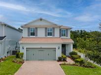 Charming two-story home featuring a brick driveway, two-car garage, and beautifully landscaped front yard at 2683 Bobcat Chase Blvd, Oakland, FL 34787