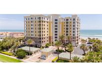 Beautiful oceanfront condominium building with palm trees and manicured landscaping, perfect for coastal living at 4071 S Atlantic Ave # 803, New Smyrna Beach, FL 32169