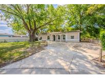 Charming single-story home with a spacious front yard and inviting curb appeal enhanced by mature trees at 4748 Amoy Ct, Orlando, FL 32811