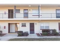 Two-story condo building featuring multiple units with individual entrances and well-maintained landscaping at 5505 Hernandes Dr # 108, Orlando, FL 32808