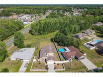 An aerial view of the property showing its proximity to neighborhood and other homes, along with the in-ground swimming pool at 602 Milan Dr, Kissimmee, FL 34758